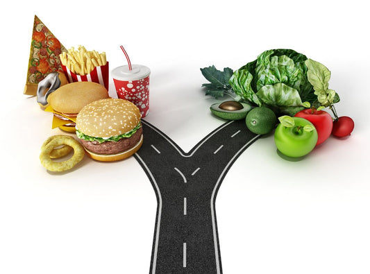 There is a road that splits and one side goes to fast food items and the other goes to healthy options like apples and lettuce.